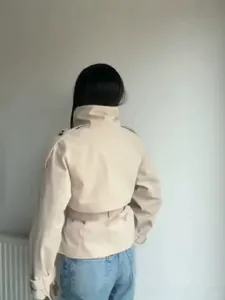 Short beige trench coat featuring a stand collar and adjustable waist belt for women