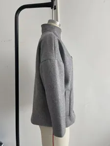 Close-up side view of a grey elegant stand-collar wool coat on a display mannequin