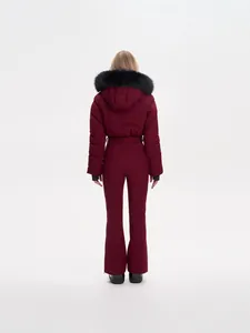 Back view of a women's burgundy one-piece ski suit featuring a luxury fur-trimmed hood