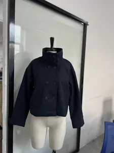 Detail of a navy blue double-breasted wool coat with a chic stand-up collar design