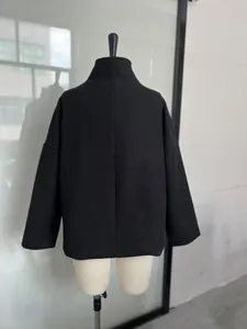 Detail back view of a black stand-collar wool coat on a professional dress form mannequin.