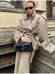 Detail einer schicken beige-kurzen Trenchcoat-Jacke mit Gürtel, Revers und weiten Ärmeln