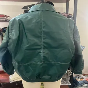 Giacca in ecopelle verde scuro da donna con cuciture a contrasto, vista posteriore foto
