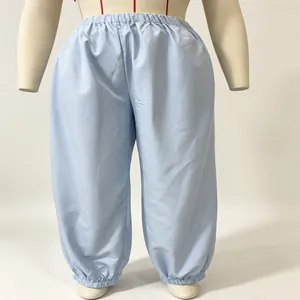Detailed view of light blue lantern pants featuring elastic waist and gathered cuffed ankles.