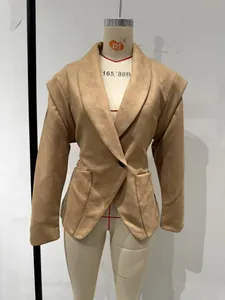Detail view of an elegant camel blazer with a cinched waist and wide lapels on a mannequin