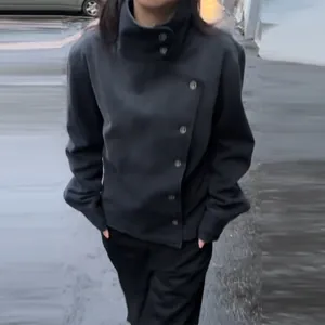 Detail of a vintage black stand collar workwear jacket with asymmetrical buttons for women.