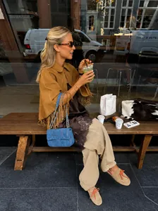 Fashionable women's lapel tassel fringe cape jacket styled in an outdoor cafe setting