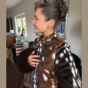 Detailed side view of a faux fur coat featuring a brown and white deer spot pattern