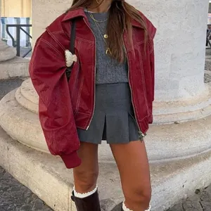 Dettaglio della giacca retrò in ecopelle rossa con cuciture a contrasto e fit oversize
