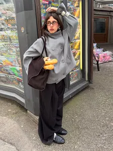 Street style detail of a grey double-breasted wool coat with standing collar