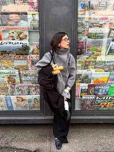 Elegant grey stand-collar buttoned wool coat for women in a chic street style setting
