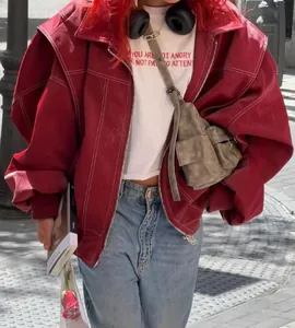 Dettaglio di una giacca oversize rossa vintage da donna con cuciture bianche a contrasto.