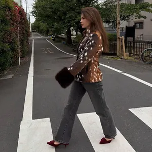 Slim-fit animal print faux fur jacket with plush cuffs worn by a woman on a street