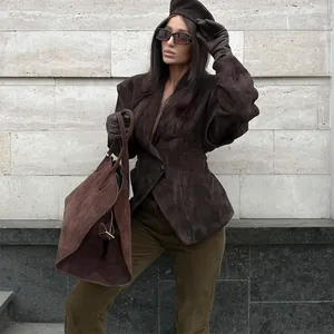 Outdoor lifestyle shot featuring a woman in an elegant brown suede lapel jacket with waist tie