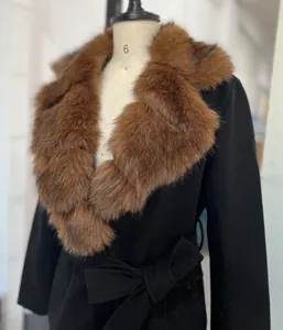 Detailopname van een elegante zwarte damesjas met een luxe bruine kraag van imitatiebont