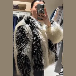 Selfie allo specchio di una donna con un pesante cappotto in finta pelliccia di volpe bicolore