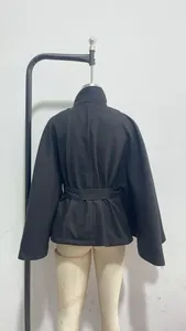 Vista trasera de una elegante chaqueta capa negra con cinturón para mujer, estilo chic.