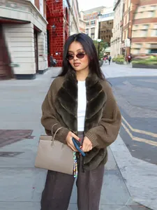 Fashion model wearing brown faux fur patchwork knit cardigan in urban street setting