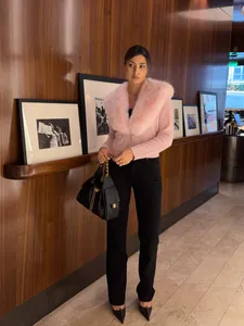 Vista a figura intera di un elegante cardigan rosa con collo di pelliccia rimovibile su modella