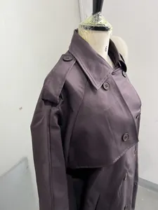 Detailansicht eines lila Trenchcoats mit Reverskragen und Knopfdetails an der Schulter