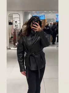 Vintage black PU leather jacket with lapel and waist tie for a chic commuter look.
