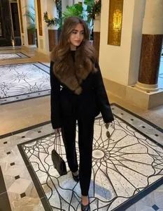Elegante zwarte wollen damesjas met grote bruine kraag van imitatiebont voor de winter.