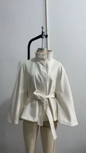 Gedetailleerd overzicht van een elegante witte wollen cape-jas met hoge kraag en riem.