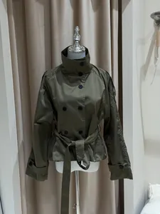 Gros plan d'un trench-coat court vert olive avec col montant et ceinture à la taille