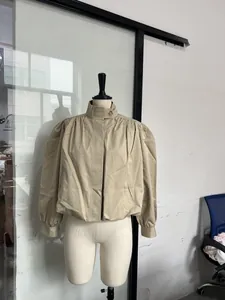 Detail view of a khaki short windbreaker with stand collar and puff sleeves on a mannequin.