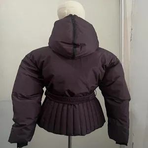Detailansicht der Rückseite einer bordeauxroten Skijacke mit Kapuze und Faltenwurf.