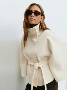 Elegant ivoren wollen jas detail met een hoge kraag en een verstelbare taille riem