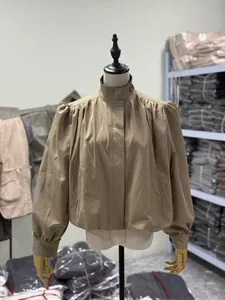 Detail shot of a tan stand-collar short windbreaker jacket on a mannequin