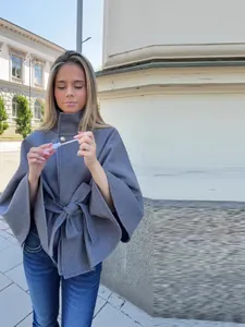 Elegante chaqueta tipo poncho gris con botón metálico y cinturón