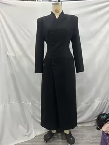 Full view of elegant long black coat with padded shoulders on a mannequin display.