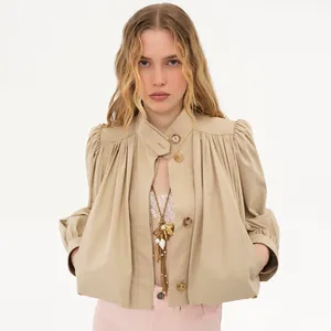 Close-up of stylish tan cropped windbreaker jacket with stand collar and puff sleeves