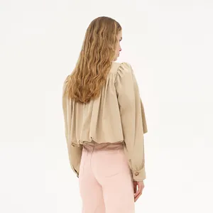 Back view of a stylish beige puff sleeve short windbreaker jacket with pink trousers