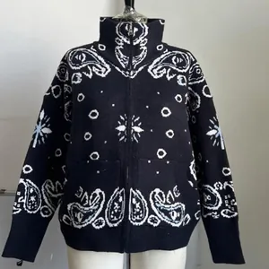 Detailed view of vintage paisley pattern on black knitted zip-up cardigan jacket