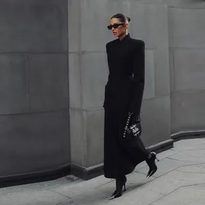 Elegant black long coat featuring structured padded shoulders and a cinched waist design