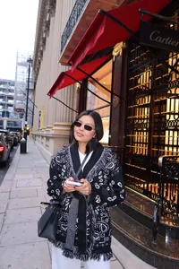 Détail de style urbain d'un cardigan en maille à motifs ethniques avec des franges