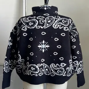 Back view of a vintage black knit cardigan featuring an intricate white paisley pattern