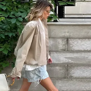 Khaki British style padded shoulder short trench coat for women in outdoor setting