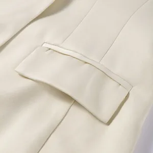 Detailaufnahme einer cremefarbenen Damenjacke mit Taschenklappe und feiner Stoffstruktur