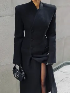 Elegant tailored long black wool coat featuring sharp shoulder pads and a cinched waist design