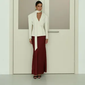 Eleganter weißer Blazer mit passendem Schal und einem luxuriösen burgunderroten Satinrock