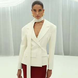 Detailansicht eines eleganten elfenbeinfarbenen Blazers mit dünnem Schal und Reverskragen.