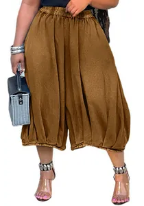 Close-up of brown baggy wide-leg trousers with elastic waist and gathered cuffs.