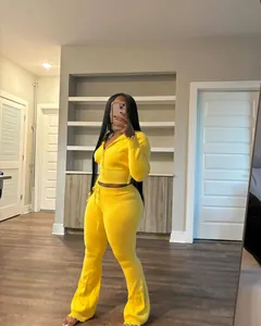 Vibrant yellow two-piece knitted set featuring a zip-up hoodie and high-waisted flared pants