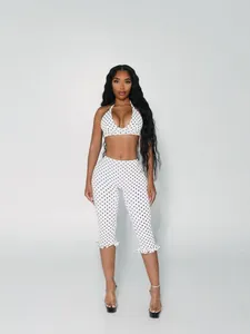 Detail of white two-piece set featuring black polka dots halter top and ruffled capris
