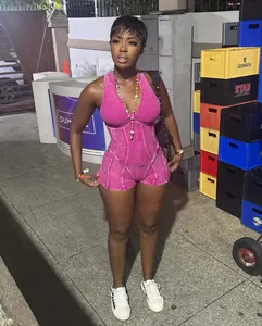 Zijaanzicht van een vrouw in een roze acid wash geribbelde romper jumpsuit met rits