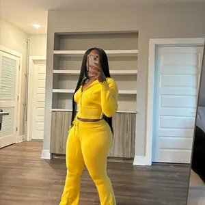 Mirror selfie view showing fit of vibrant yellow knitted tracksuit set with flared pants